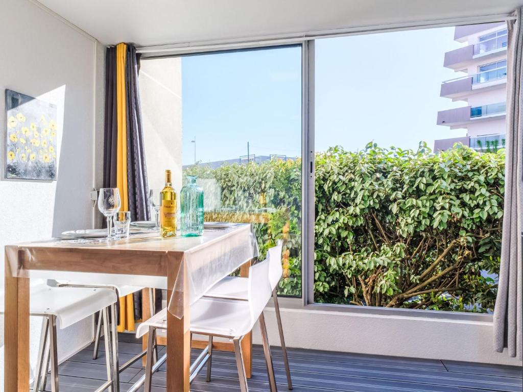 une salle à manger avec une table et des chaises et une grande fenêtre dans l'établissement Studio Port Arcachon-2 by Interhome, à Arcachon