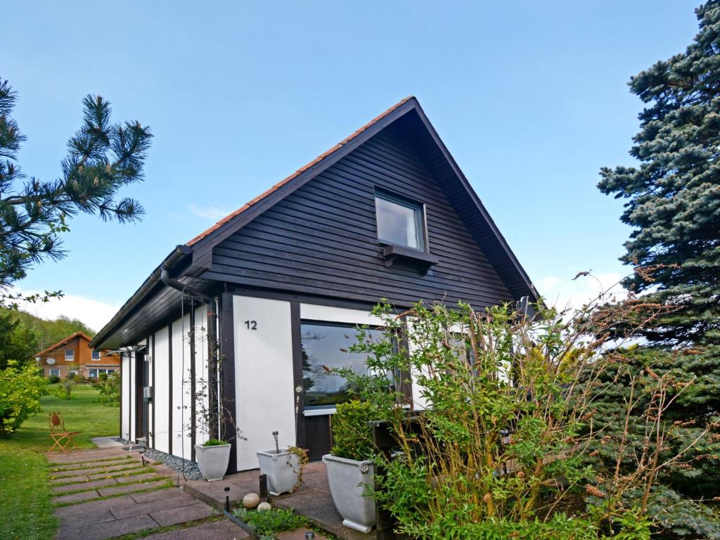 una casa con techo negro y puertas blancas en Holiday Home Merle by Interhome en Vörden