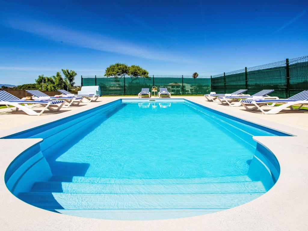 a swimming pool with lounge chairs and a swimming pool at Holiday Home Casa do Sol by Interhome in Patroves