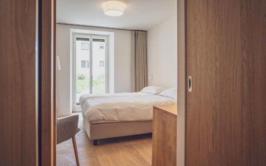 a bedroom with a bed and a window at Hotel Joseph's House in Davos