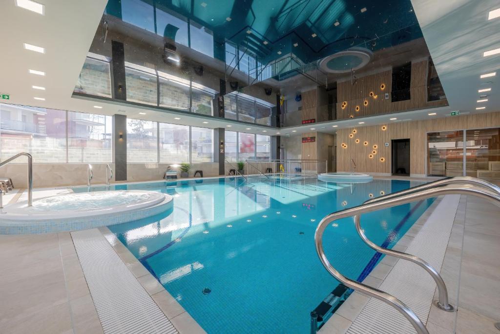 una gran piscina de agua azul en un edificio en Klifowa Resort with SPA, Fitness & Kids Club by Renters, en Rewal