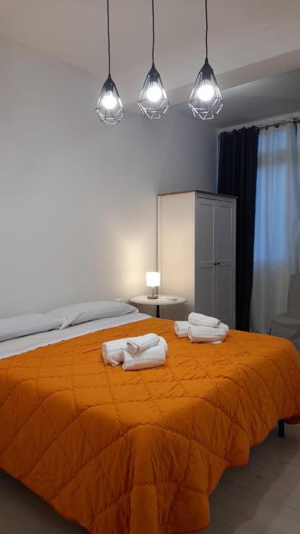 a bedroom with a large orange bed with towels on it at Guest House Aio Sardegna in Cagliari