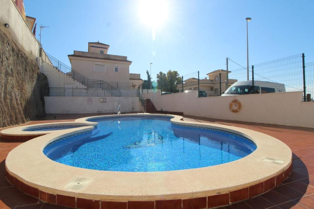 une grande piscine dans un patio avec un bâtiment dans l'établissement Sea view holiday home sleeps 10, à Murcie