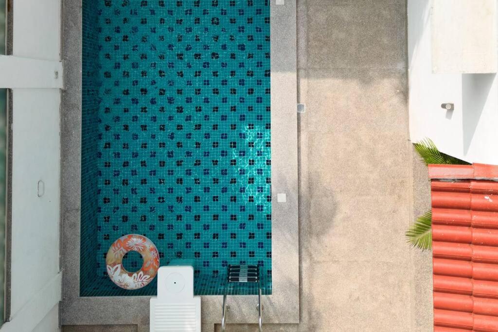 Verla的住宿－Ra-3Bed Villa W/PVTpool in Assagao by Masaya Stays，蓝色瓷砖游泳池旁有甜圈