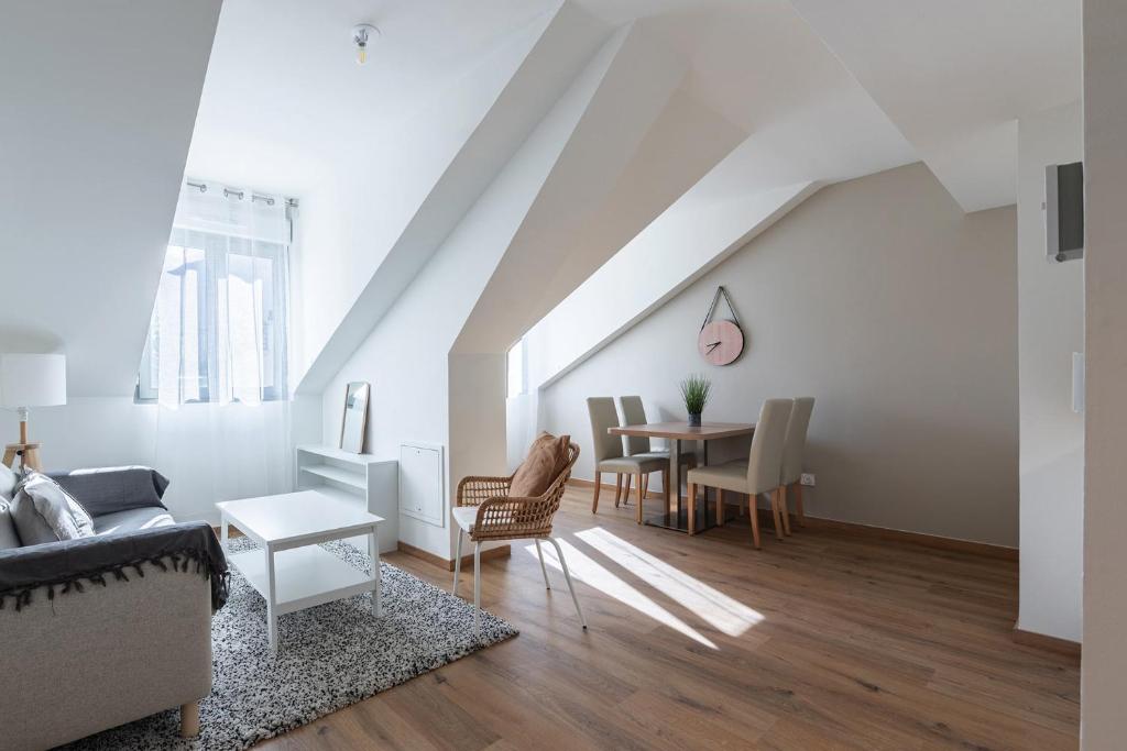 a living room with a couch and a table at OVELIA Aix-les-bains - Le Pavillon Victoria in Aix-les-Bains