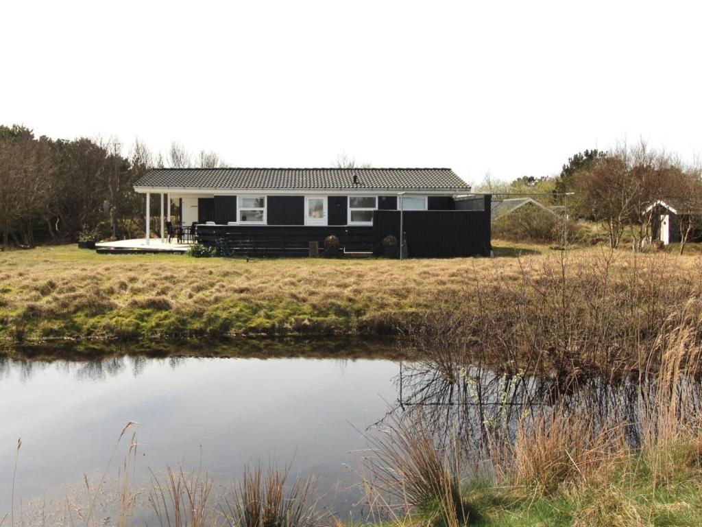 una casa con un estanque delante de ella en Holiday Home Bentine - 400m from the sea in Western Jutland by Interhome en Fanø