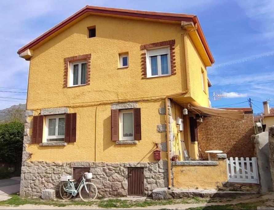 una casa amarilla con una bicicleta estacionada frente a ella en La Casita Amarilla, en Los Molinos