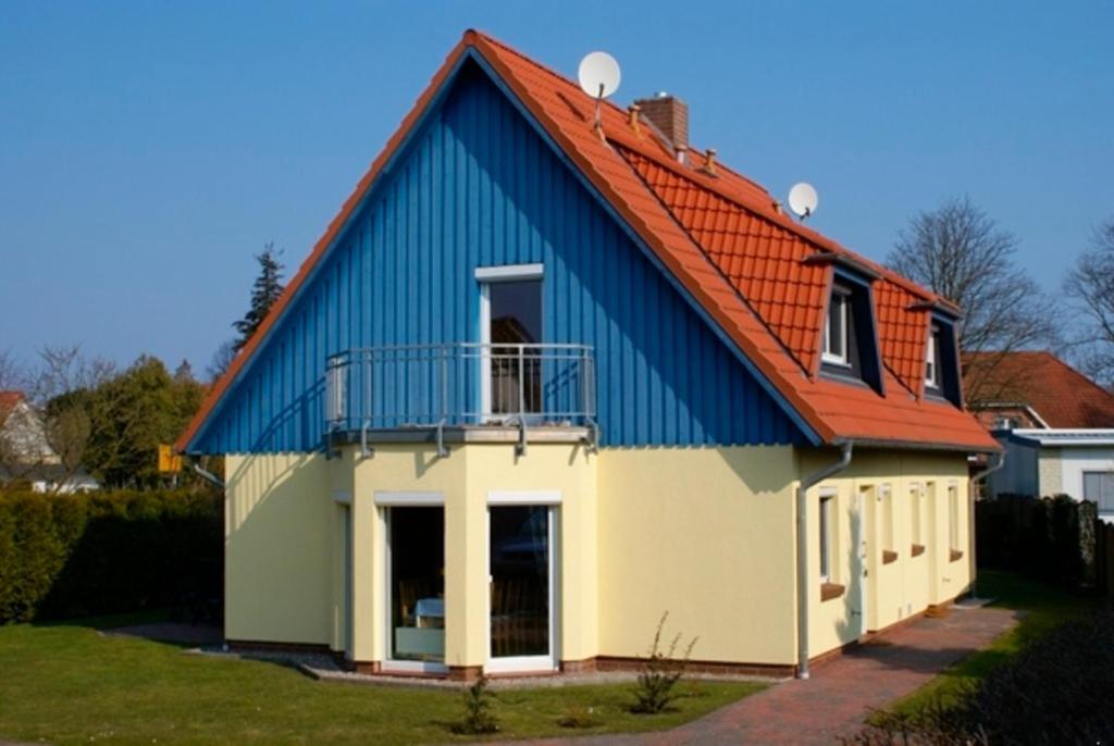 a blue and white house with an orange roof at Luv in Zingst
