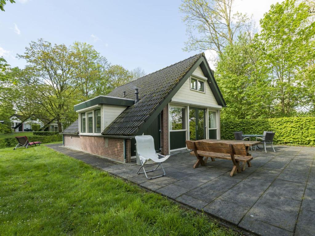 a small house with a picnic table and a bench at Holiday Home De Smokkelaar bg 127 by Interhome in Simpelveld