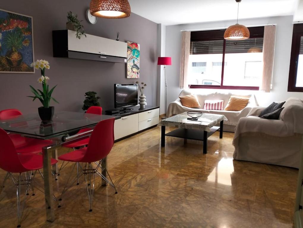 a living room with a table and red chairs at Moderno y Amplio apartamento Valdeolleros SRosa in Córdoba