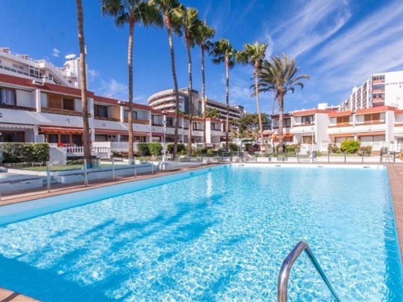 a large swimming pool with palm trees and buildings at Deluxe Las Marinas Beach in Maspalomas