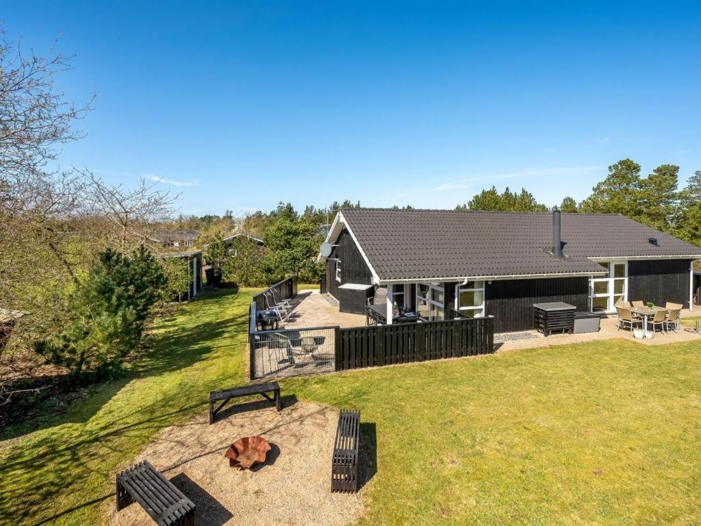 una casa con un patio con bancos y una casa en Holiday Home Rekke - 300m to the inlet in Western Jutland by Interhome, en Skjern