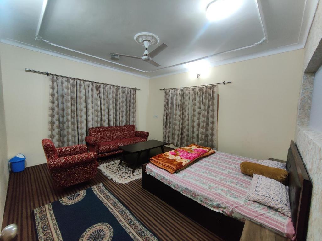 1 dormitorio con 1 cama y 1 silla en Home Away From Home Cute 3 bedroom House G floor en Srinagar