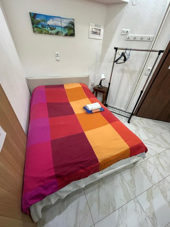 uma cama num quarto com um cobertor colorido em Ano Poli Studios 4 em Tessalônica
