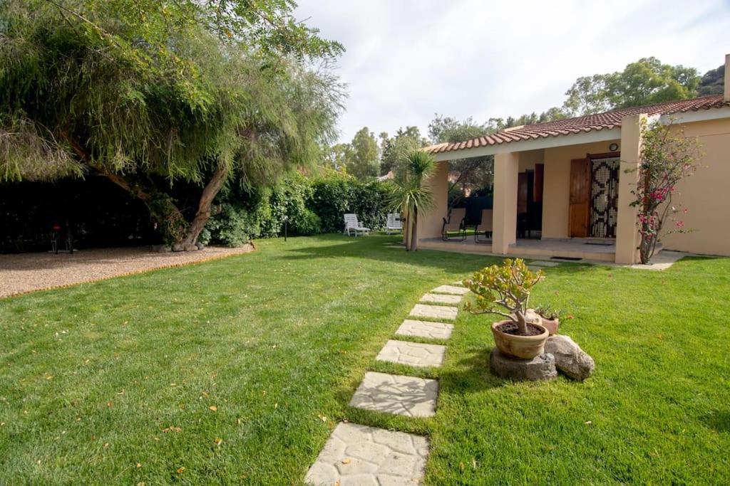 a yard with a house and a potted plant at Casa Kody a 500 mt dalla spiaggia di Geremeas in Geremeas