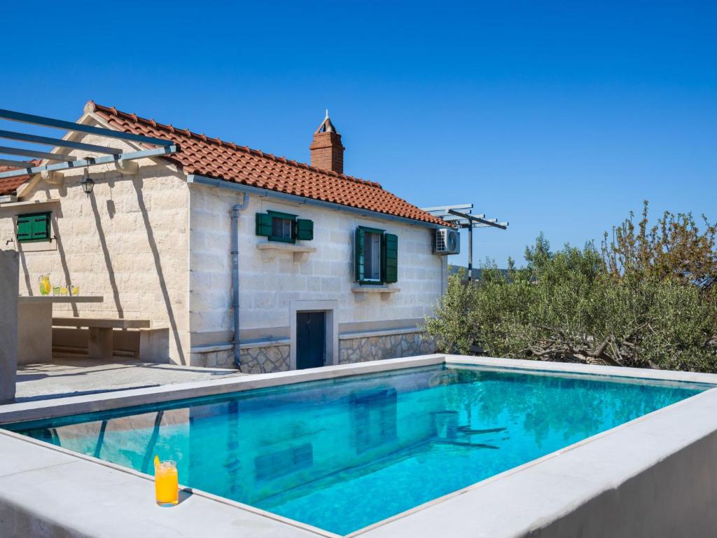 une villa avec une piscine en face d'une maison dans l'établissement Holiday Home Dubrove by Interhome, à Pražnice