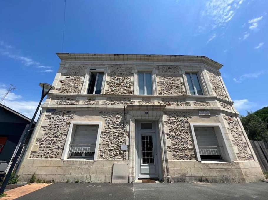 a stone building with three windows on a street at La Teste cœur de ville in La Teste-de-Buch