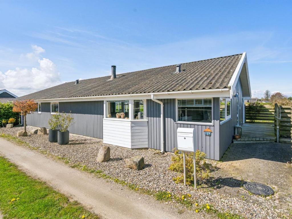 una casa gris con techo gris en Holiday Home Wehrhart - all inclusive - 125m from the sea by Interhome en Otterup