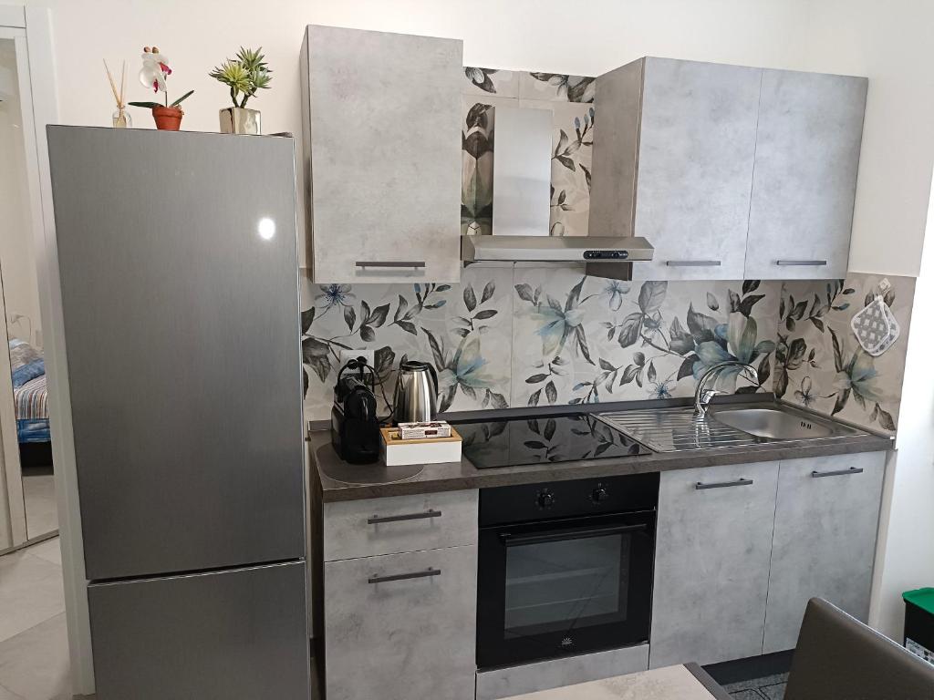 una cucina con lavandino e frigorifero di Orchidea Home a Busto Arsizio