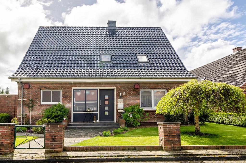 a brick house with a black door at Ferienwohnung Hausrosengarten in Hage