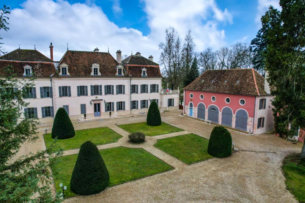 a large white building with a courtyard with trees at CHATEAU DE QUINCEY in Quincey