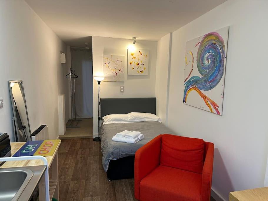 ein kleines Zimmer mit einem Bett und einem roten Stuhl in der Unterkunft Garden Apartment with free Parking and EV in Bristol