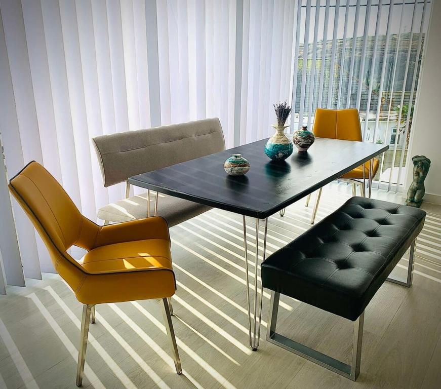 a dining room with a table and chairs at Relax in style at my stunning Holywell Beach home in Holywell Bay