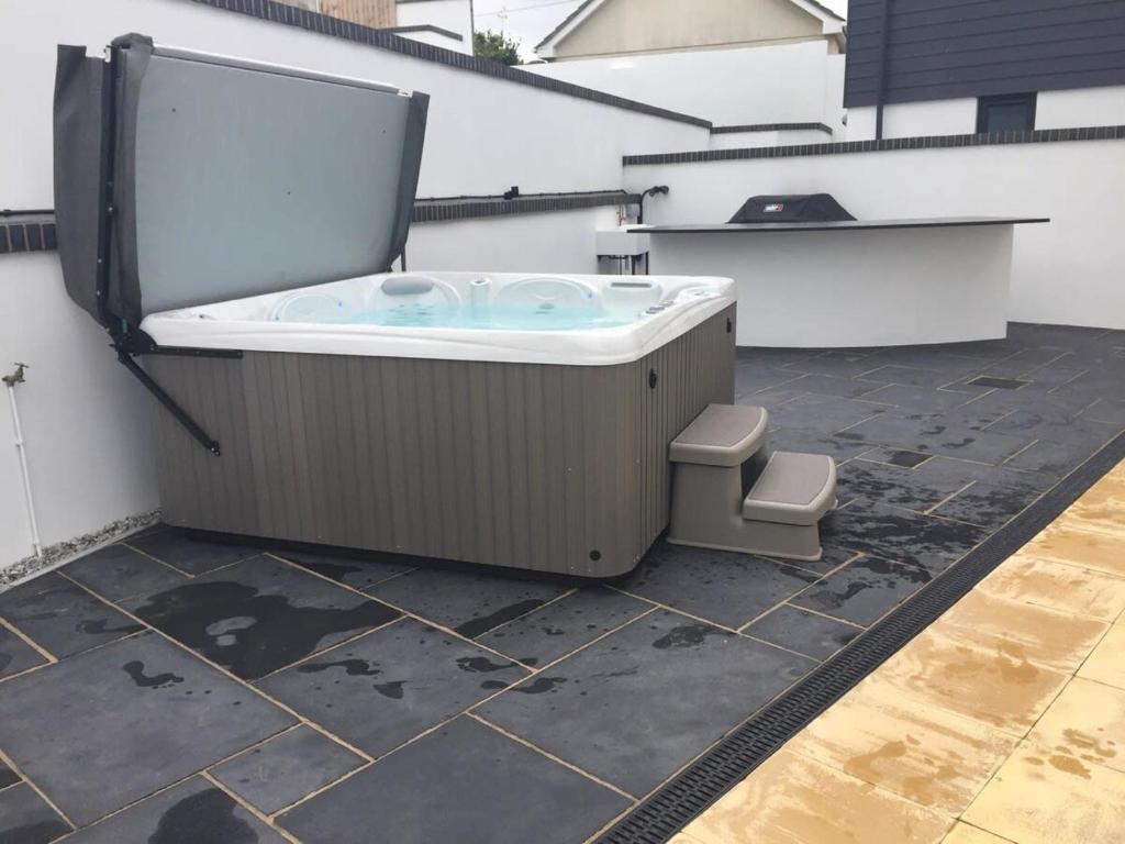 a jacuzzi tub sitting on top of a patio at Relax in style at my stunning Holywell Beach home in Holywell Bay