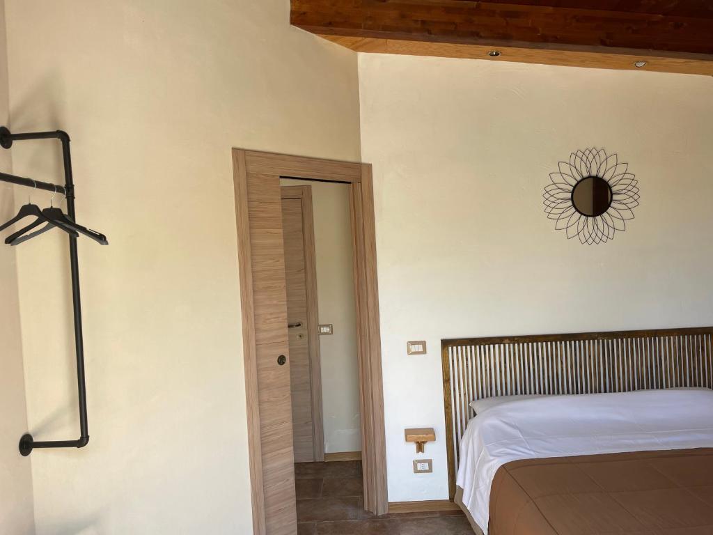 サン・レオーネにあるVilla Miramareのベッドルーム1室(ベッド1台、壁掛け時計付)