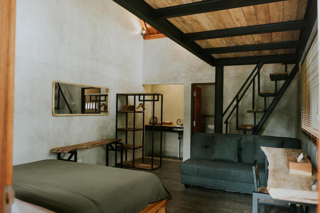 een slaapkamer met een bed, een trap en een bank bij Country side room northern UBUD in Tegalalang