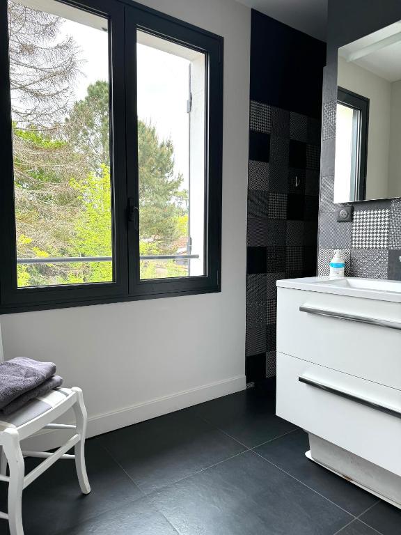 baño con lavabo blanco y ventana en Villa basquaise avec piscine, en Andernos-les-Bains