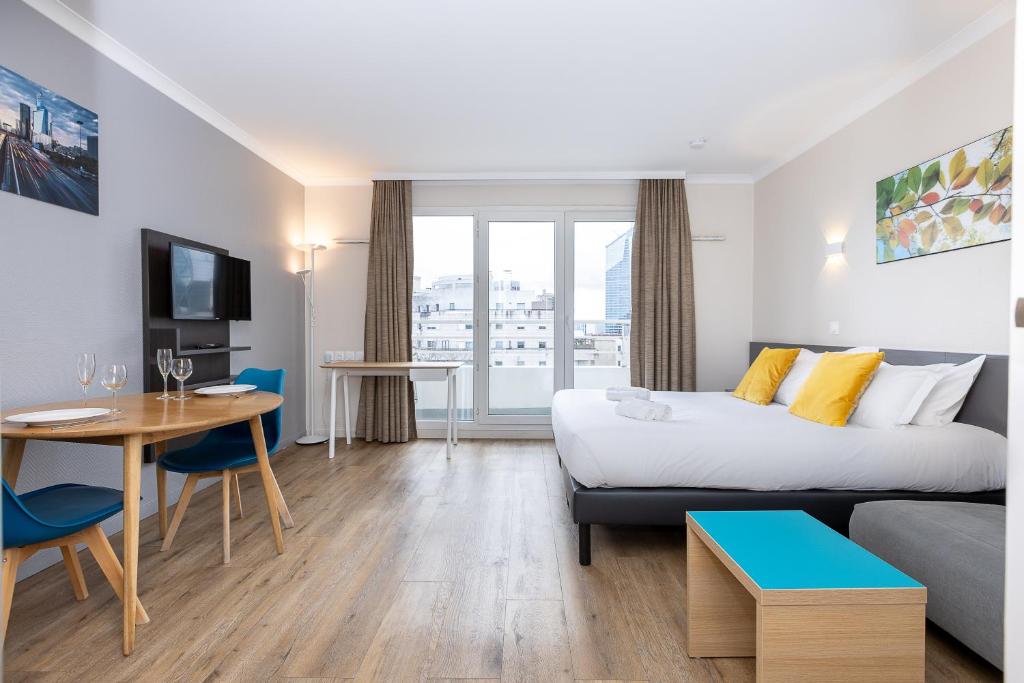 Habitación de hotel con cama y mesa en Star Of Life, en Courbevoie