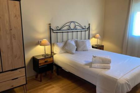 a bedroom with a large white bed with two lamps at Casita Planes Surroca in Bourg-Madame