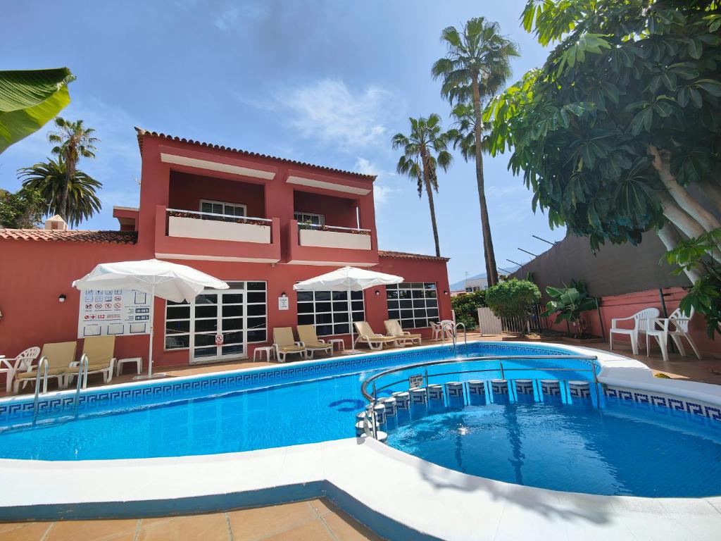 uma casa com piscina em frente a um edifício em Hotel Don Cándido em Puerto de la Cruz