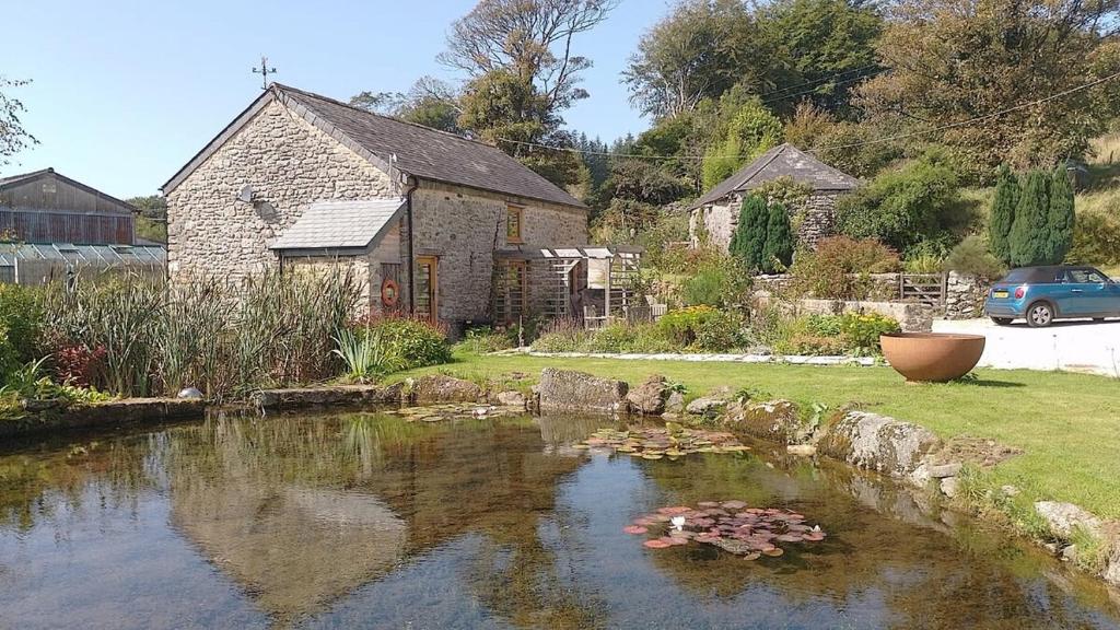 a pond in front of a house with a yard at The Meeting House in Sheepstor