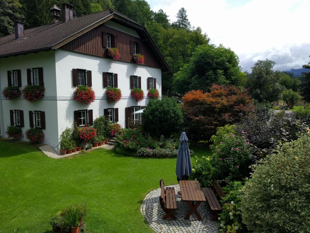 uma casa com um jardim e um guarda-chuva em Jörgleggerhof em Nikolsdorf