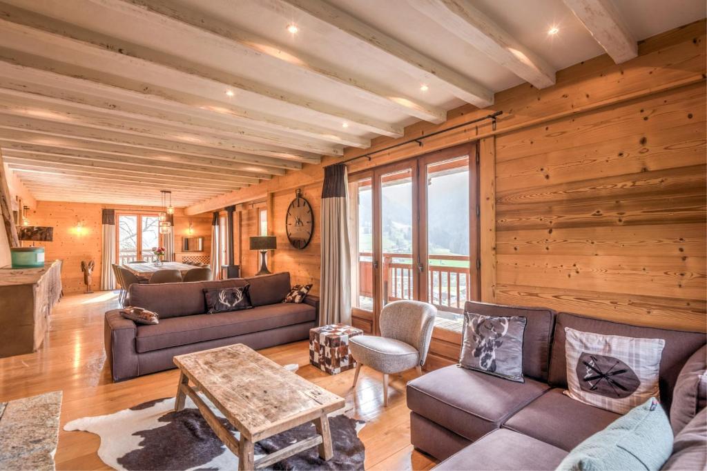 a living room with a couch and a table at Chalet Les Cimes - Welkeys in Praz-sur-Arly