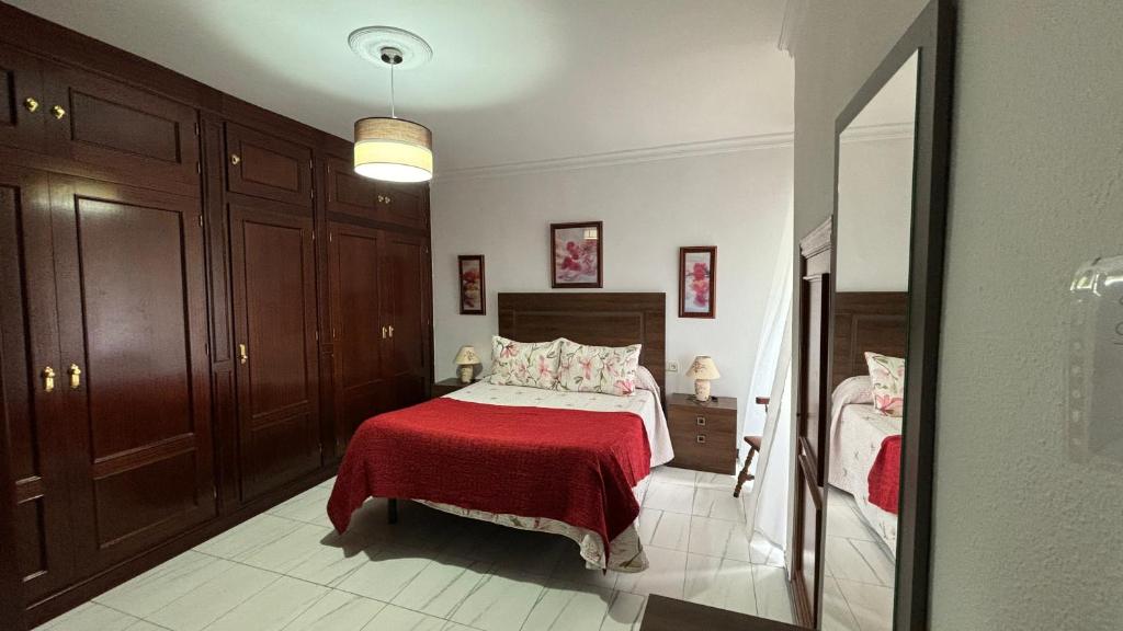 a bedroom with a bed with a red blanket at Apartamento Maldonado in Ronda