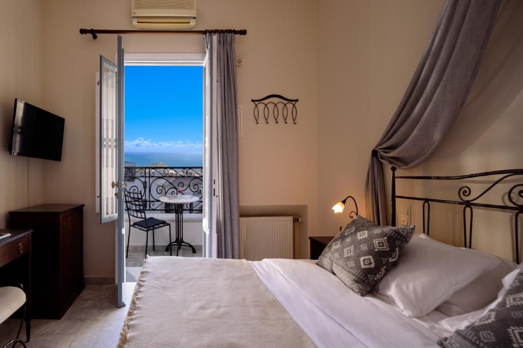 a bedroom with a bed and a view of the ocean at Ikio Concept Santorini in Pirgos