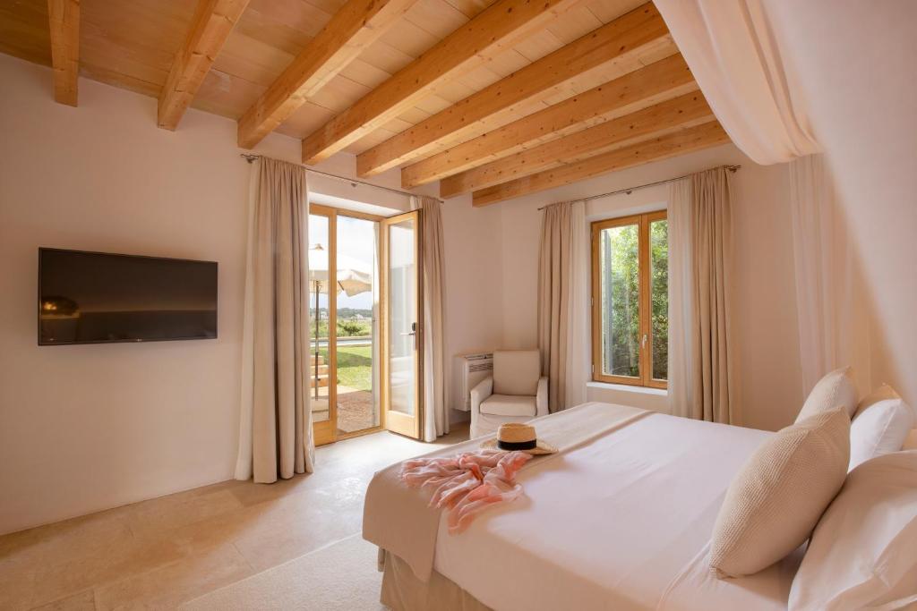 a bedroom with a large white bed and a television at Fontsanta Hotel Thermal & Spa - Adults Only in Colònia de Sant Jordi