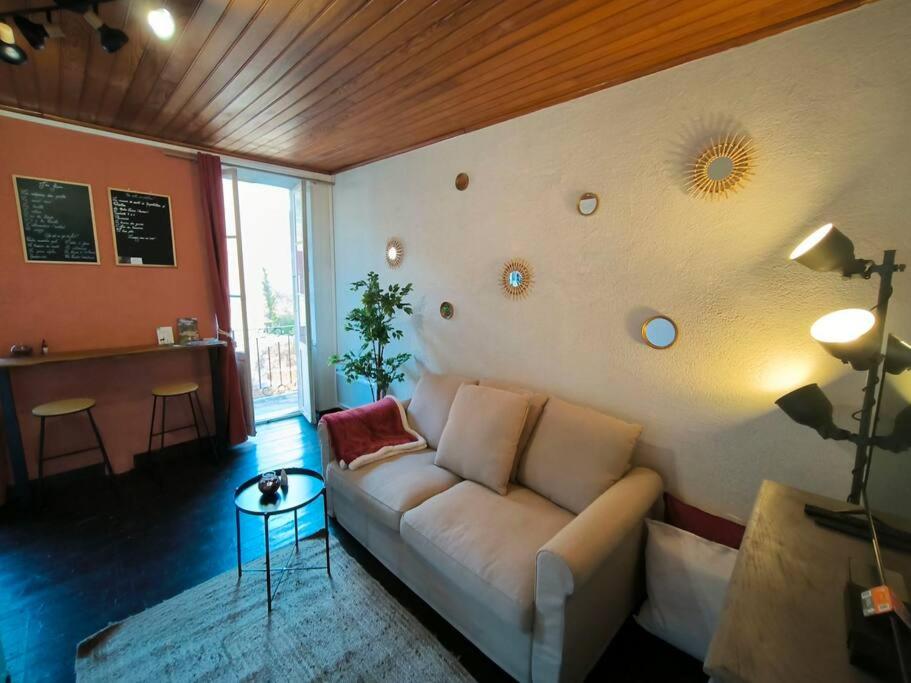 un salon avec un canapé et une table dans l'établissement Élégant studio au centre-ville, à Saint-Martin-Vésubie