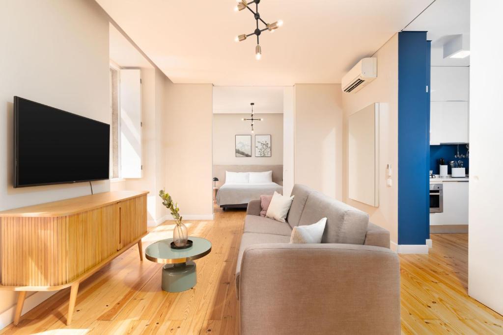 a living room with a couch and a tv at Limehome Lisbon Rua do Arsenal in Lisbon