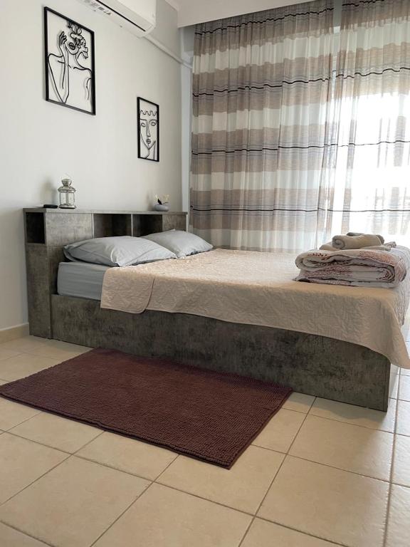 Un dormitorio con una cama grande con ventana. en Kate's Studio with view and free parking, en Serres