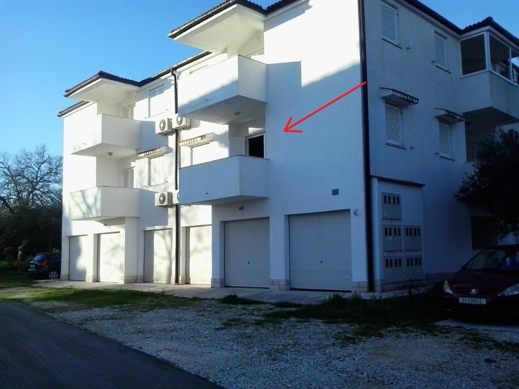 un edificio con una flecha roja en el costado. en Apartment Kiko, en Rogoznica