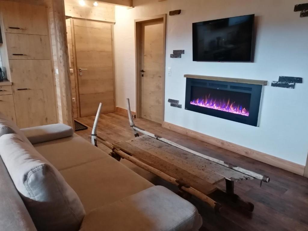 ein Wohnzimmer mit einem Sofa und einem Kamin in der Unterkunft Greenheart Aussee in Obersdorf