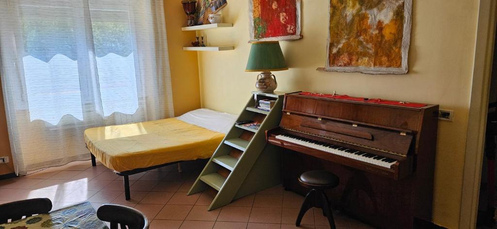 ローマにあるLa Casetta Di Tizianaのピアノとベッドが備わる小さな客室です。