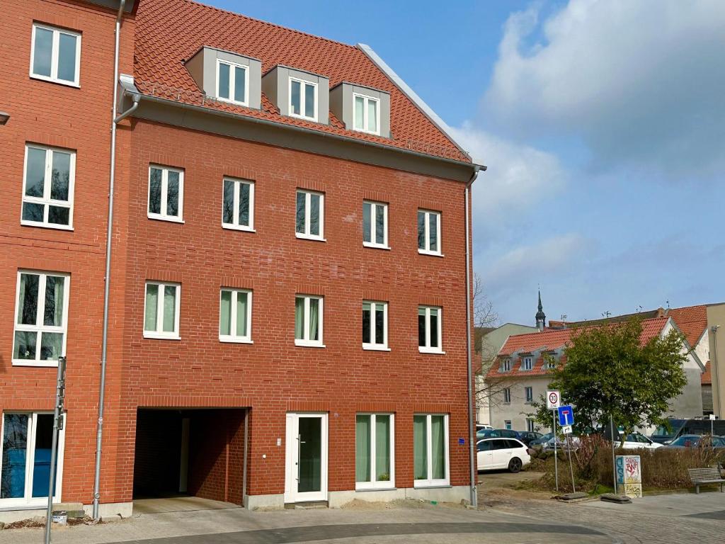 un grand bâtiment en briques rouges avec un garage dans l'établissement Altstadt-Studio Frankenwall, à Stralsund