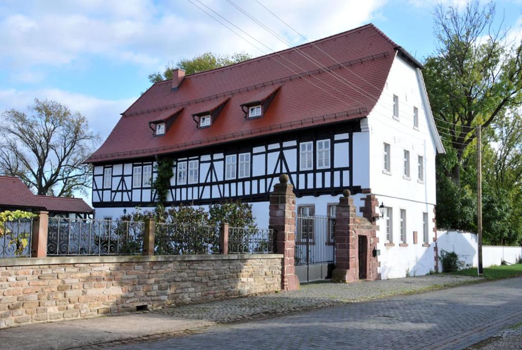 una casa blanca y negra con techo rojo en Rittergut Thürungen, en Kelbra
