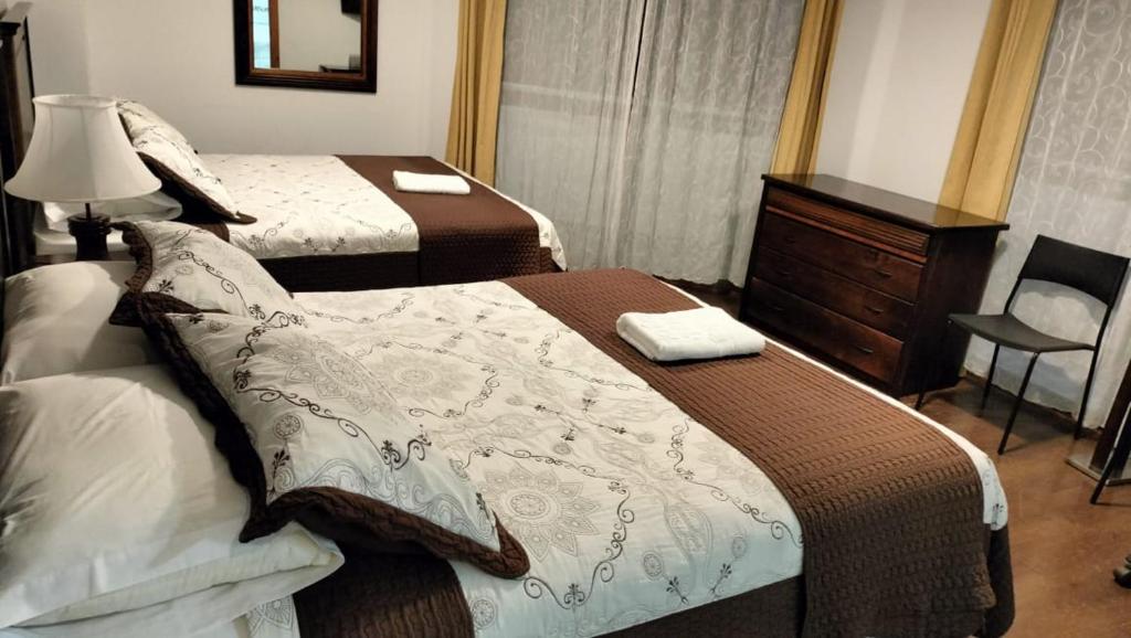 a hotel room with two beds and a dresser at Hotel 5° Estación in Caldera