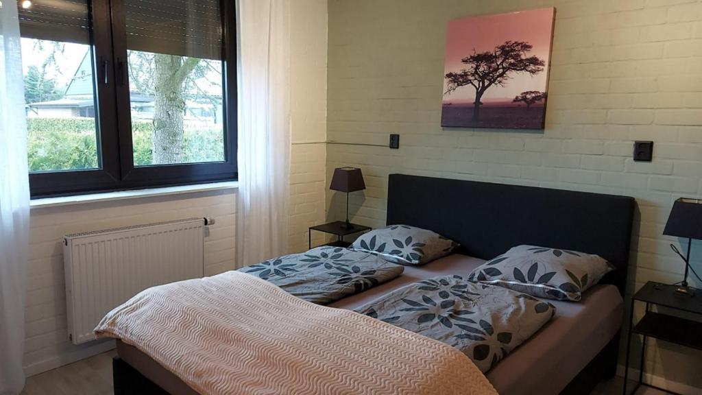 1 cama con 2 almohadas junto a una ventana en Plattedijk - vakantiehuis 25-41, en Lemmer